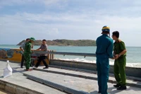 Lực lượng chức năng đóng các lối đi trên bờ kè chắn sóng tại làng biển Nhơn Hải. Ảnh: Ngọc Nhuận