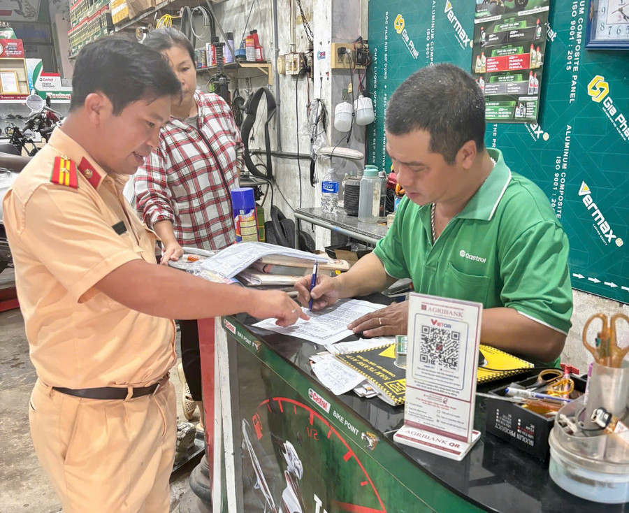 Một cơ sở sửa chữa, kinh doanh mô tô trên địa bàn phường Hoài Nhơn Bắc ký cam kết không tự ý thay đổi kết cấu, hình dáng, kích thước, đặc tính kỹ thuật của xe. Ảnh: ĐVCC chu-co-so-sua-xe-1.jpg