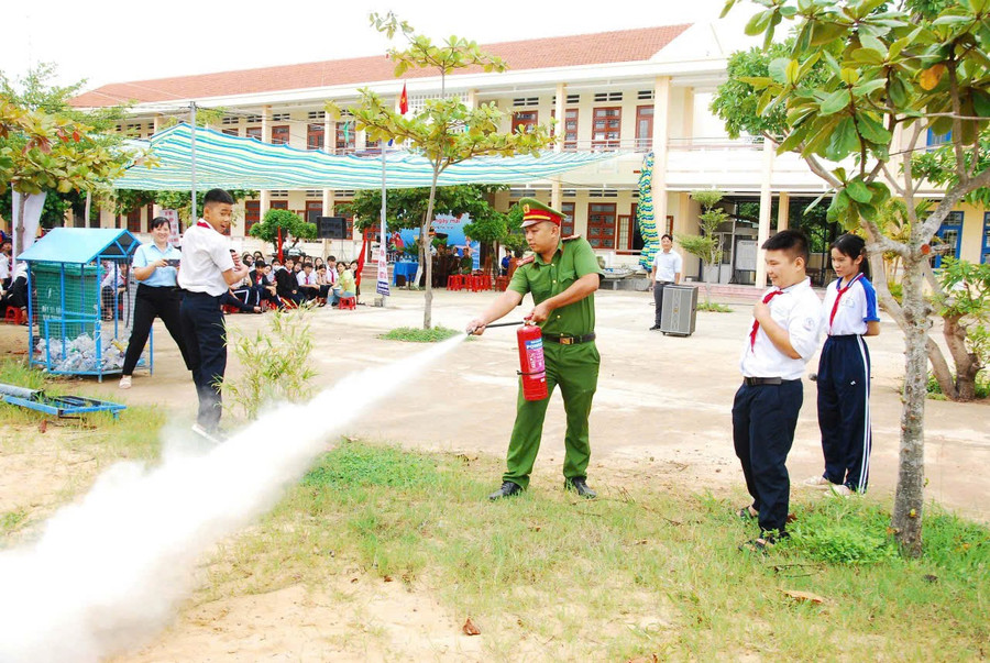 Công an phường Quy Nhơn Đông hướng dẫn học sinh cách sử dụng bình chữa cháy xách tay. Ảnh: N.L z6957891986720-dca95371331e871b4aeca9b210bd14fa.jpg