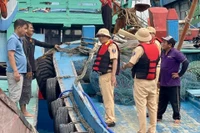 Cảnh sát đường thủy vận động các ngư dân neo đậu tàu thuyền. Ảnh: N.L