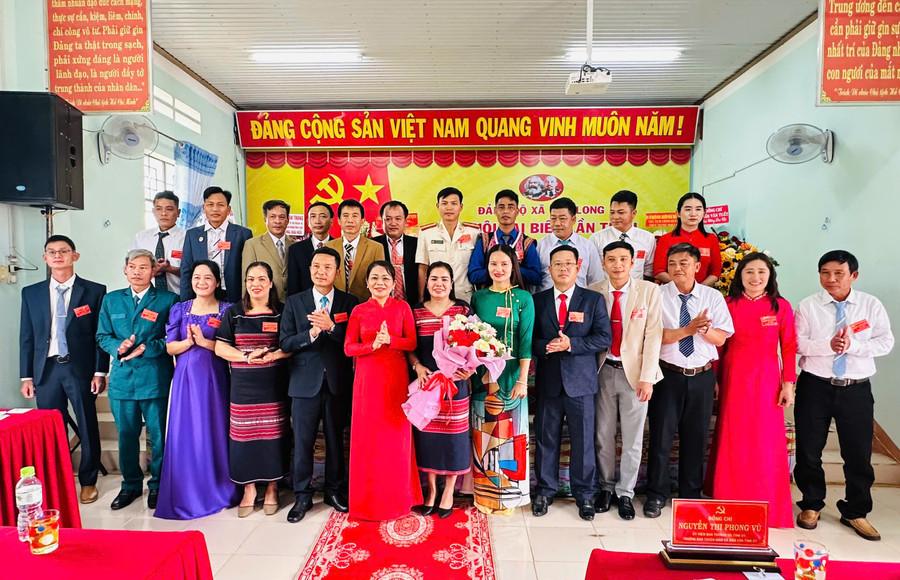 Trưởng Ban Tuyên giáo và Dân vận Tỉnh ủy Nguyễn Thị Phong Vũ (hàng đầu, thứ 6 từ trái sang) tặng hoa chúc mừng Ban Chấp hành Đảng bộ xã Chơ Long khóa I. Ảnh: Thúy Ngọ chucc.jpg