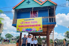 Thầy Vũ Văn Tùng (thứ 2 từ trái sang) trao tặng nhà nhân ái cho 2 học trò mồ côi xã Pờ Tó. Ảnh: Vũ Chi