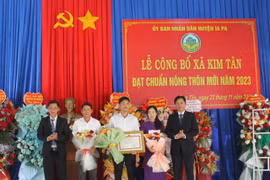 Bí thư Huyện ủy Nguyễn Minh Trưởng (bìa trái) và Chủ tịch UBND huyện Huỳnh Văn Trường trao bằng công nhận đạt chuẩn nông thôn mới cho Đảng bộ và Nhân dân xã Kim Tân. Ảnh: Vũ Chi