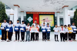 Thầy Vũ Văn Tùng phối hợp với Ban Giám hiệu Trường Tiểu học và THCS Đinh Núp tặng học bổng cho học sinh nghèo vượt khó của trường. Ảnh: Văn Tùng