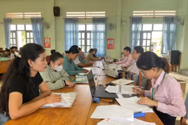 Chị Rcom H’Sra ( bìa trái, buôn Rưng Ma Nin) làm thủ tục vay vốn tại điểm giao dịch xã Ia Rbol. Ảnh: Vũ Chi