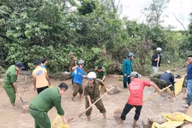 Cán bộ, chiến sĩ Công an xã Ia Pa phối hợp hỗ trợ gia cố ngầm tràn thôn Mơ Nang 2, đảm bảo người dân và phương tiện mini có thể qua lại an toàn. Ảnh: Hòa Bình