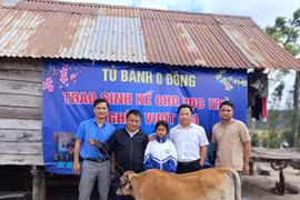 Thầy Vũ Văn Tùng (thứ 2 từ trái sang) trao tặng con bê sinh sản cho em Đinh H’Niu (lớp 7, Trường THCS Lương Thế Vinh). Ảnh: Văn Tùng