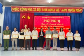 Bí thư Đảng ủy xã Trịnh Thị Hồng (đứng giữa) tặng giấy khen cho các tập thể có thành tích xuất sắc trong công tác bầu cử. Ảnh: Vũ Chi