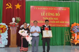 Phó Chủ tịch UBND thị xã Đặng Xuân Toàn (đứng giữa) trao quyết định công nhận đạt chuẩn nông thôn mới năm 2024 cho cán bộ và nhân dân bôn Hiao. Ảnh: Vũ Chi