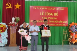 Phó Chủ tịch UBND thị xã Đặng Xuân Toàn (đứng giữa) trao quyết định công nhận đạt chuẩn nông thôn mới năm 2024 cho cán bộ và nhân dân bôn Hiao. Ảnh: Vũ Chi