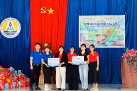 Đại diện Quỹ Hy vọng và Công ty Cổ phần bán lẻ Kỹ thuật số FPT trao kinh phí và trang thiết bị dạy học hỗ trợ Trường Tiểu học và THCS Nguyễn Viết Xuân tái thiết sau bão. Ảnh: Vũ Chi