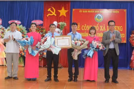 Giám đốc Sở Nông nghiệp và PTNT Lưu Trung Nghĩa (bìa phải) và Chủ tịch UBND huyện Phú Thiện Trịnh Văn Sang (bìa trái) trao bằng công nhận và tặng hoa chúc mừng xã Ia Peng đạt chuẩn nông thôn mới. Ảnh: Vũ Chi