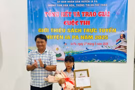 Ông Nguyễn Thái Sơn-Giám đốc Trung tâm Văn hóa-Thông tin và Thể thao huyện trao giải A cho em Nahria Rose An Nhiên (lớp 2B, Trường Tiểu học Võ Thị Sáu). Ảnh: Vũ Chi