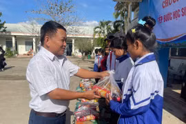 Thầy Tùng trao quà cho các em học sinh bị ảnh hưởng bởi mưa lũ. Ảnh: Vũ Chi