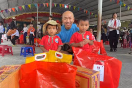 Các em học sinh vui mừng nhận quà từ chương trình. Ảnh: Vũ Chi