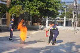 Lực lượng chuyên nghiệp hướng dẫn các em học sinh cách xử lý đám cháy bình gas. Ảnh: ĐVCC