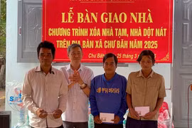 Bí thư Thị ủy Ayun Pa Trần Quốc Khánh (thứ 2 từ trái sang) tặng quà cho các hộ dân được bàn giao nhà thuộc chương trình xóa nhà tạm, nhà dột nát xã Chư Băh. Ảnh: Vũ Chi