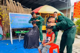 Cán bộ, chiến sĩ Kho Kỹ thuật K54 cắt tóc miễn phí cho trẻ em địa phương. Ảnh: Vũ Chi