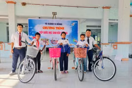 Thầy Vũ Văn Tùng (bìa phải, người phụ trách Tủ bánh 0 đồng) phối hợp với Ban Giám hiệu Trường Tiểu học và THCS Đinh Núp tặng xe đạp cho các em học sinh có hoàn cảnh đặc biệt khó khăn của trường. Ảnh V.C