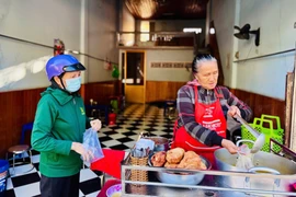 Bà Nguyễn Thị Thu Hồng (bìa phải) đang múc bánh canh cho khách. Ảnh: Thái Bình