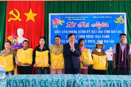 Đại diện lãnh đạo Văn phòng đăng ký đất đai tỉnh tặng quà cho các hộ nghèo tại buôn Ji. Ảnh: Thanh Tâm