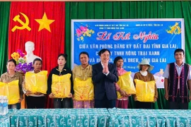 Đại diện lãnh đạo Văn phòng đăng ký đất đai tỉnh tặng quà cho các hộ nghèo tại buôn Ji. Ảnh: Thanh Tâm