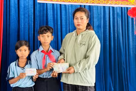 Em Nay Ti Mô Thê (đứng giữa) và Nay H’Ý trao trả lại số tiền nhặt được cho chị Rcom H’Nguyệt. Ảnh: ĐVCC