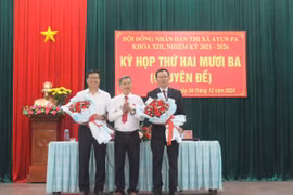 Bí thư Thị ủy, Chủ tịch HĐND thị xã Trần Quốc Khánh (đứng giữa) tặng hoa chúc mừng tân Chủ tịch UBND thị xã nhiệm kỳ 2021-2026 Trần Anh Tuấn (bìa phải) và ông Nguyễn Trường Sơn. Ảnh: Vũ Chi