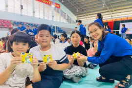 Chị Rah Lan H’Thùy (Bí thư Chi đoàn tổ dân phố 6) tặng quà cho các em nhỏ tham gia sinh hoạt hè. Ảnh: Vũ Chi