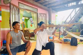 Anh Lok hướng dẫn con gái út cách ngắm bắn nỏ sao cho chính xác nhất. Ảnh: Vũ Chi