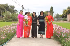 Chị em phụ nữ xã Pờ Tó rạng rỡ bên con đường hoa thôn Bình Hòa. Ảnh: Vũ Chi