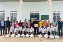 Ông Khuất Đình Viện (thứ 6 từ phải sang, Giám đốc Công ty TNHH doanh nghiệp xã hội hỗ trợ cộng đồng Tây Nguyên, nguyên Phó Tổng biên tập Báo Gia Lai) trao quà cho hộ nghèo bị thiệt hại do mưa lũ tại xã Ia Tul. Ảnh: Vũ Chi