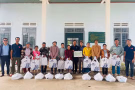 Ông Khuất Đình Viện (thứ 6 từ phải sang, Giám đốc Công ty TNHH doanh nghiệp xã hội hỗ trợ cộng đồng Tây Nguyên, nguyên Phó Tổng biên tập Báo Gia Lai) trao quà cho hộ nghèo bị thiệt hại do mưa lũ tại xã Ia Tul. Ảnh: Vũ Chi