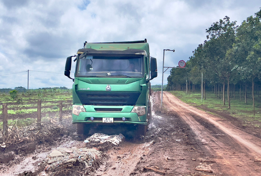 Tài xế xe tải chỉ cần lấn sang đường bê tông bên cạnh sẽ lập tức bị chặn xe yêu cầu nộp tiền "hỗ trợ sửa chữa đường bê tông" thì mới cho xe đi. Ảnh: Minh Phương lai-xe.jpg