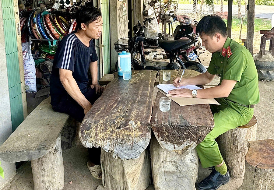 Công an xã yêu cầu các cơ sở sửa chữa xe máy ký cam kết không độ chế xe trái phép. Ảnh: Minh Phương cam-ket.jpg
