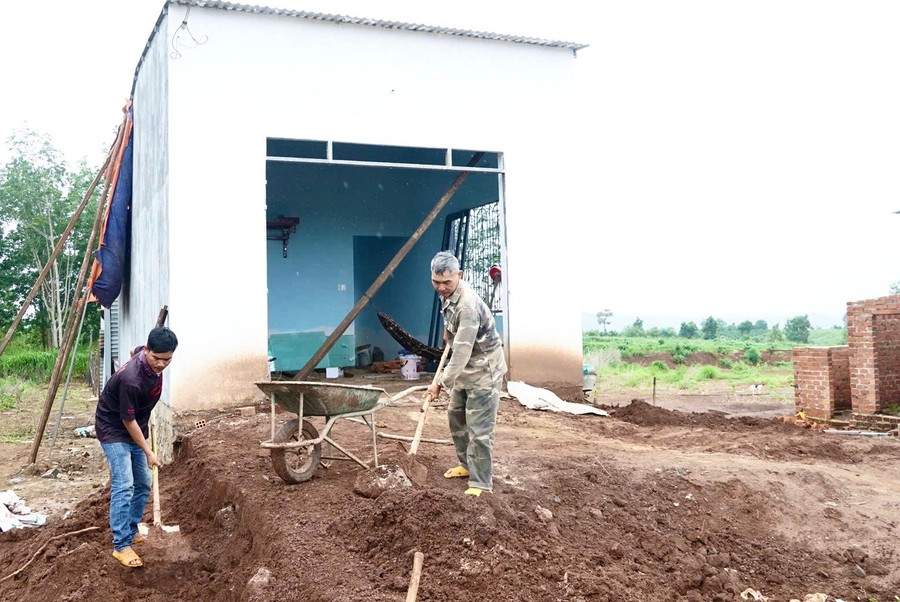 Gia đình ông Hoàng Văn Thành (làng Ar Trớ, xã Lơ Pang) xây nhà ở mới tại khu tái định cư. Ảnh: Minh Phương hoang-van-thanh.jpg
