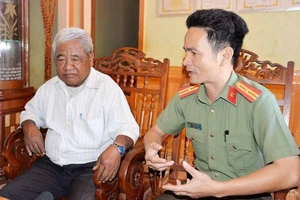 Anh Lê Ngọc Hưng (khi còn là Thiếu tá, Đội trưởng Đội An ninh Công an huyện Chư Prông) tiếp xúc tranh thủ già làng Rơ Mah Klua (làng Lâm So, xã Thăng Hưng) để vận động người dân chấp hành tốt các quy định của pháp luật. Ảnh: T.T.T