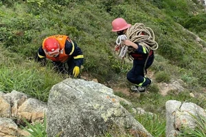 Cảnh sát đu dây đưa thi thể nạn nhân lên khỏi vách núi ở Nhơn Lý