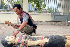 Nghệ nhân Nay Lâm hoàn thiện bức tượng gỗ người phụ nữ Jrai. Ảnh: V.C