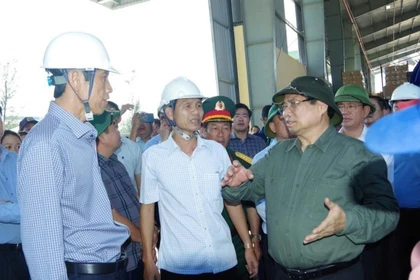 Giám đốc PJICO Bình Định Nguyễn Hướng Nam (đầu tiên bên trái) báo cáo với Thủ tướng về việc tham gia công tác khắc phục hậu quả cơn bão số 13, đảm bảo quyền lợi cho khách hàng tham gia bảo hiểm. Ảnh: T.SỸ