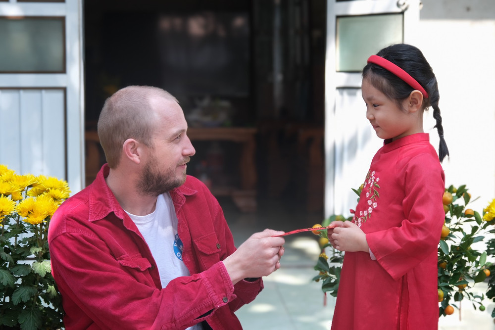 Anh Tilman Wolbert mừng tuổi người già, trẻ em theo phong tục của người Việt. Ảnh: Hoàng Ngọc dscf1059.jpg
