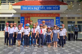 Lực lượng chức năng phối hợp cùng nhà trường trao tặng mũ bảo hiểm đạt chuẩn, hình thành thói quen đội mũ khi tham gia giao thông cho học sinh.