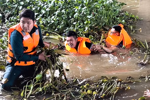 Cán bộ, chiến sĩ và người dân cùng vớt lục bình và rác để khơi thông dòng chảy