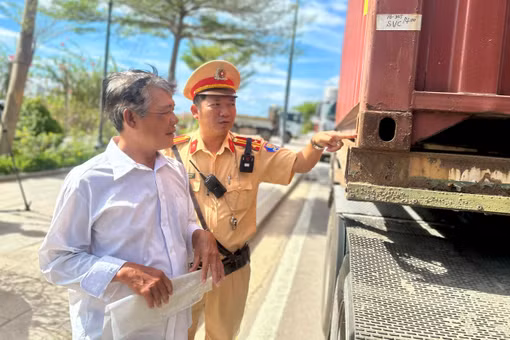 Cán bộ Đội Cảnh sát giao thông đường bộ số 4 nhắc nhở tài xế về các điểm chưa đảm bảo tại chốt giữ của container. Ảnh: K.A