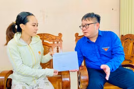 Phó Bí thư Tỉnh đoàn Nguyễn Chí Hiếu (bìa phải) gửi lời chia buồn và trao tiền hỗ trợ cho người thân của anh Đinh Văn Quang. Ảnh: Bích Kiều