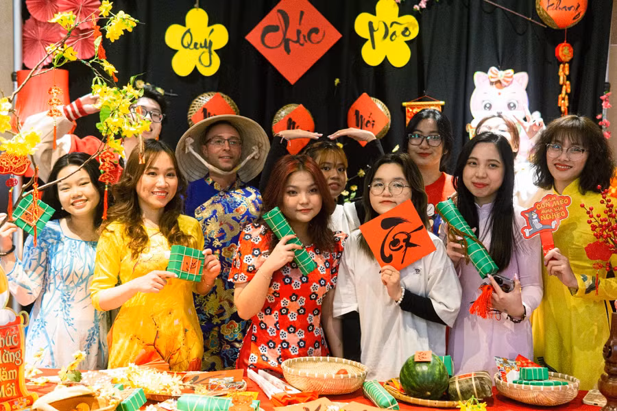 9X quê Gia Lai Trần Ngọc Bảo (bìa phải) cùng các sinh viên Việt Nam đón Tết cổ truyền tại Canada, đồng thời giới thiệu văn hoá Việt đến bạn bè các nước. Ảnh: NVCC