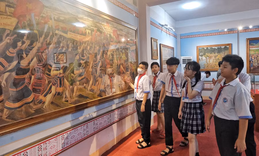Các em học sinh TP. Pleiku tìm hiểu tranh của họa sĩ Xu Man. Ảnh: Hoàng Ngọc