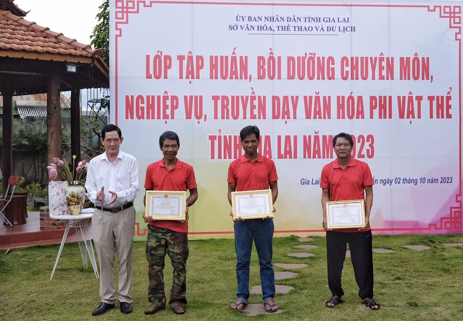 Phó giám đốc Sở Văn hóa-Thể thao và Du lịch Nguyễn Đức Hoàng tặng giấy khen cho 3 nghệ nhân xuất sắc. Ảnh: Hoàng Ngọc