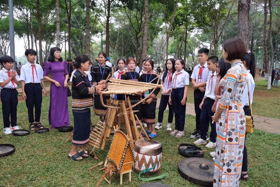 Cô và trò Trường THCS Nguyễn Du tìm hiểu về các nhạc cụ dân tộc Tây Nguyên. Ảnh: Hoàng Ngọc