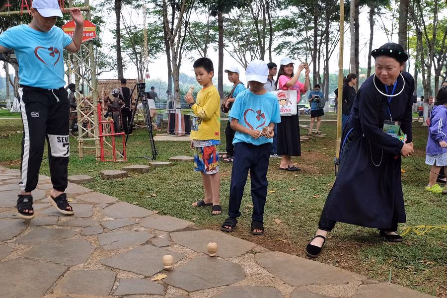 Học sinh hào hứng chọi cù cùng các nghệ nhân dân tộc Tày. Ảnh: Hoàng Ngọc